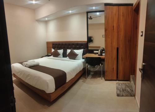 a bedroom with a bed and a desk in it at Aditya Inn in Guwahati