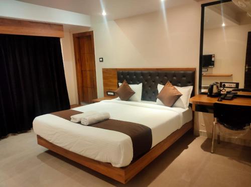 a bedroom with a large bed and a desk at Aditya Inn in Guwahati