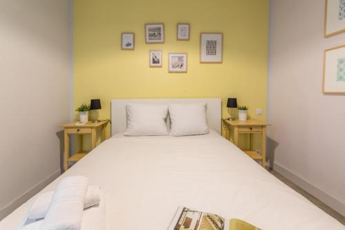 une chambre avec un grand lit blanc avec deux tables dans l'établissement WS Mouffetard - Panthéon, à Paris