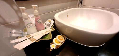 a bathroom with a sink and toiletries on a counter at The Mareeya Place in Kamala Beach