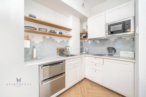eine weiße Küche mit weißen Schränken und Geräten in der Unterkunft Apartament Czechowska Prestige in Lublin