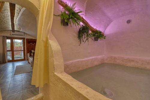 a bath tub in a room with a purple ceiling at Barlang Noszvaj in Noszvaj