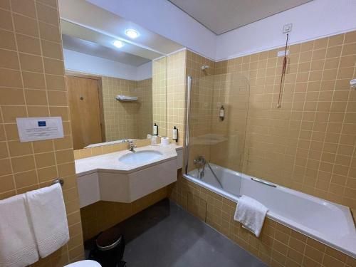 a bathroom with a tub and a sink and a bath tub at Flag Hotel Porto Maia in Águas Santas