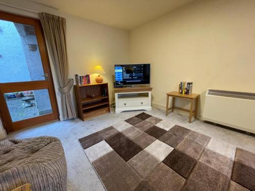 a living room with a flat screen tv and a couch at Lovely and Spacious 2BD Holiday Retreat Ballater in Ballater