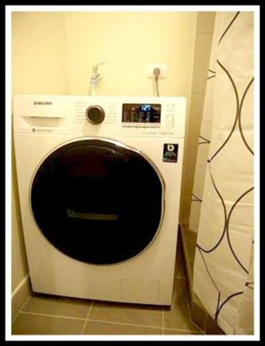 a white washing machine sitting in a room at Patrick s Place in Davao City