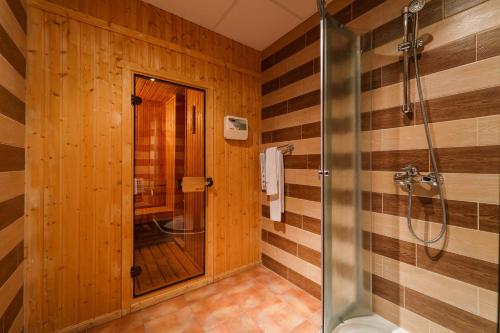 a bathroom with wooden walls and a shower stall at Hotel Ego - Free Parking - Top Central Location in Plovdiv