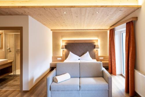 a bedroom with a bed and a book on a chair at Hotel Tiroler Herz in Hinterhornbach