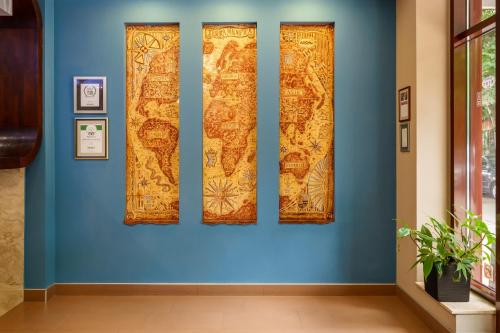 a blue wall with four pieces of art on it at Hotel Ego - Free Parking - Top Central Location in Plovdiv