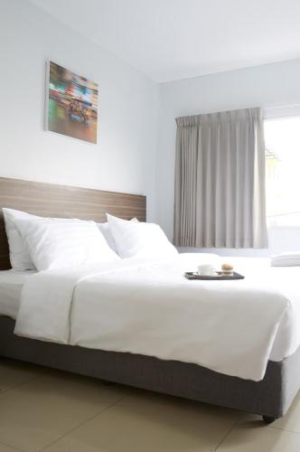 a large white bed in a bedroom with a window at Praso Residence in Bangkok