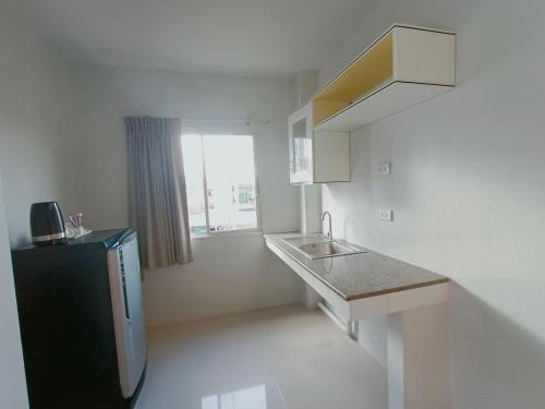 a small kitchen with a sink and a refrigerator at Praso Residence in Bangkok