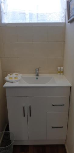 uma casa de banho com um lavatório branco e uma janela em Roadside Motel em Waiouru