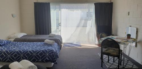 懷烏魯的住宿－Roadside Motel，客房设有两张床和大窗户。