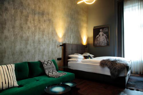 a bedroom with a bed and a green couch at Leo Boutique Rooms - Adults Only in Budapest