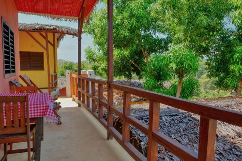 a porch of a house with a table and chairs at Colibri Lodge in Ambatoloaka