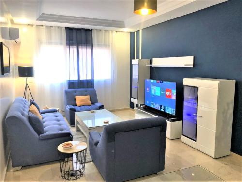 a living room with two chairs and a flat screen tv at SUPER APPART Marrakech - Confort Propreté Proximité in Marrakech