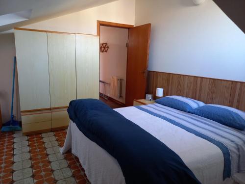 um quarto com uma cama grande e lençóis azuis em Piccola mansarda a Porto San Giorgio em Porto San Giorgio