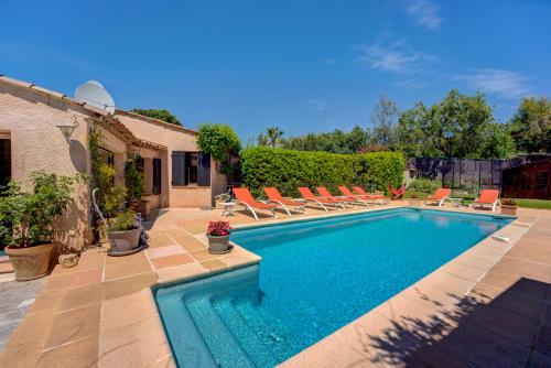 une piscine avec des chaises longues à côté d'une maison dans l'établissement MAGNIFIQUE VILLA 8 PERSONNES, à Vallauris