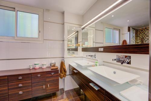 une salle de bain avec deux lavabos et un grand miroir dans l'établissement MAGNIFIQUE VILLA 8 PERSONNES, à Vallauris