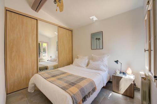 une chambre avec un grand lit et un miroir dans l'établissement MAGNIFIQUE VILLA 8 PERSONNES, à Vallauris