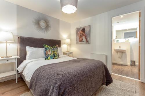 a bedroom with a large bed and a bathroom at Executive 7 Glasgow City in Glasgow