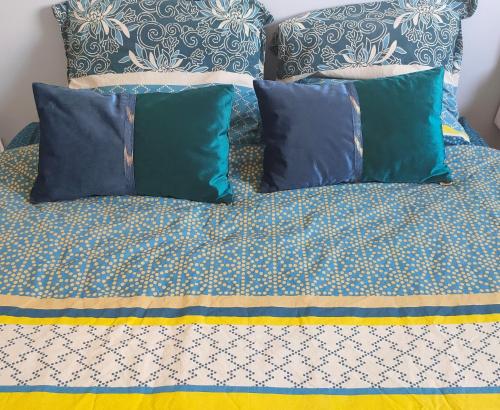 a bed with blue pillows and blue and white sheets at LA MAISON BLEUE, à 20 mn de Strasbourg, sur la route des vins, jusqu'à 6 personnes, Sélestat in Sélestat