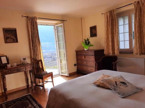 ein Schlafzimmer mit einem Bett, einer Kommode und einem Fenster in der Unterkunft B&B Il Grappolo in Bianzone
