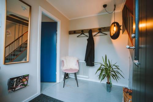 a hallway with a pink chair and a plant at Brekkustova - Modern, cosy and spacious apartment in Klaksvík