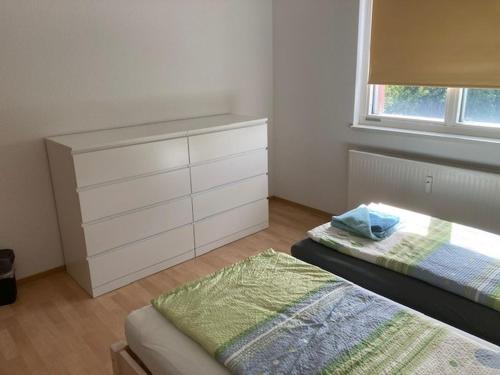 a bedroom with two beds and a dresser and a window at Touristisches Begegnungzentrum Melchow in Melchow