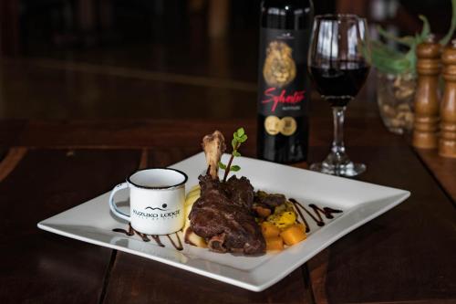 a plate of food and a cup of coffee on a table at Kuzuko Lodge in Addo