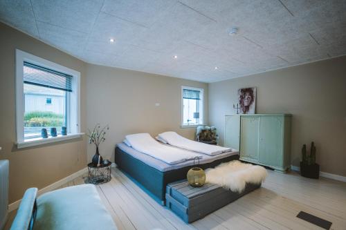 a bedroom with two twin beds and a window at Brekkustova - Modern, cosy and spacious apartment in Klaksvík