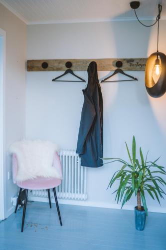 a room with a wooden beam with a chair and a plant at Brekkustova - Modern, cosy and spacious apartment in Klaksvík