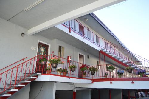 a building with potted plants on a balcony at Glass Slipper Inn - Stanford Palo Alto in Palo Alto