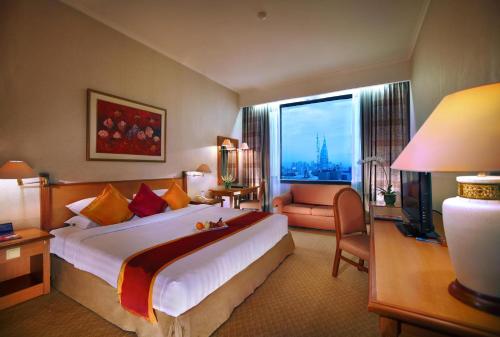 a hotel room with a large bed and a window at Menara Peninsula Hotel in Jakarta