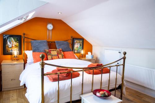 a bedroom with a bed with an orange wall at Seagulls Nest Beachfront Apartment With 3 Bedrooms in Hastings