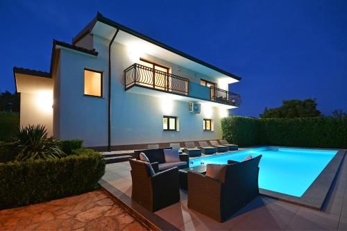 a villa with a swimming pool at night at Villa Bisko with heated pool & jacuzzi in Trilj