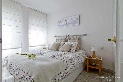 Habitación blanca con cama y ventana en MARICEL Apartment En la playa, en Calafell
