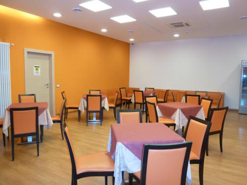 a dining room with tables and chairs in a room at Hotel Fiera in Bolzano