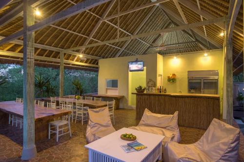 a restaurant with a table and chairs and a bar at Komodo Garden in Nusa Lembongan