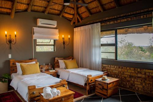a bedroom with two beds and two windows at Vida Nova Kruger in Marloth Park