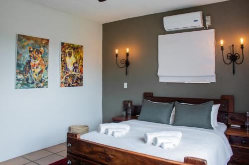 1 dormitorio con 1 cama con 2 toallas en Vida Nova Kruger en Marloth Park