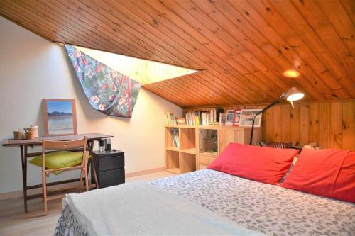 1 dormitorio con cama, escritorio y techo de madera en SCroce Apt close to Prato della Valle, en Padua