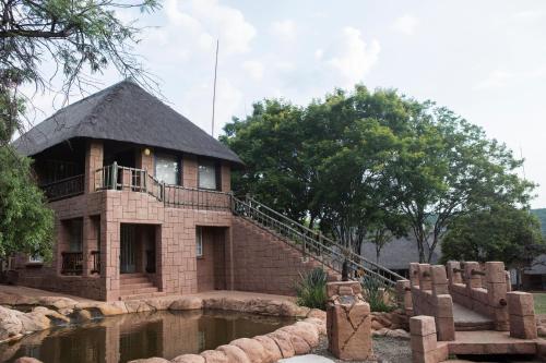 a small brick building with a pond in front of it at Zebra Nature Reserve in Cullinan