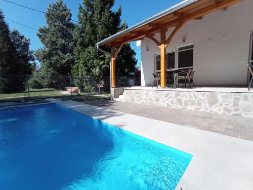 a swimming pool in front of a house at Relax Apartment in Fonyód