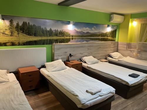 a room with three beds and a painting on the wall at Eldom-Noclegi Pracownicze Daleka 12 in Wągrowiec