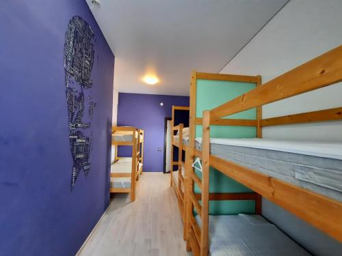a room with two bunk beds and a purple wall at Academy of Hostel in Kostroma