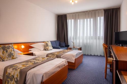 a hotel room with two beds and a television at Hotel Novi Zagreb in Zagreb