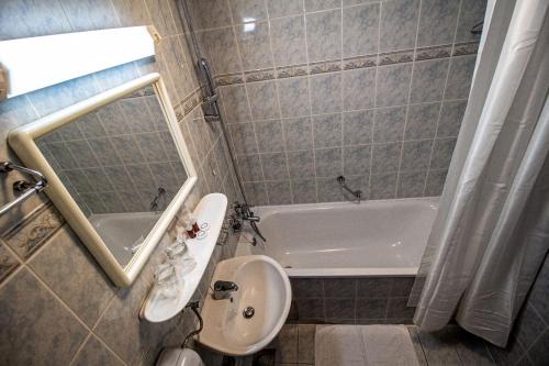 Hotel Novi Zagreb في زغرب: حمام مع حوض وحوض استحمام ومرحاض