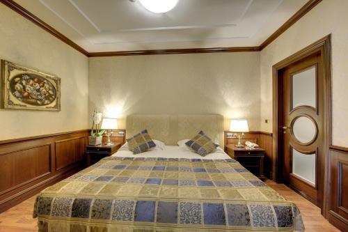 a bedroom with a large bed with two night stands at Hotel Splendid in Baveno