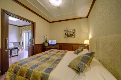 a bedroom with a bed and a television in it at Hotel Splendid in Baveno