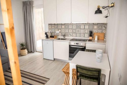 a kitchen with white appliances and a table with chairs at Casa do Gato Boémio in Leiria